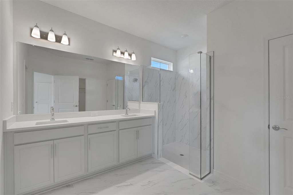 35424 Tuscan Hill Road Dade City, FL 33525 - Photo 34 of 42 a bathroom with a double vanity sink and mirror