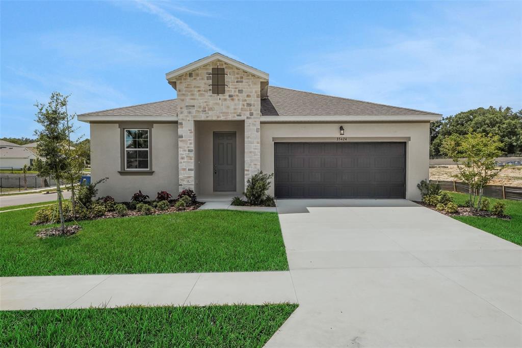 35424 Tuscan Hill Road Dade City, FL 33525 - Photo 5 of 42 a front view of a house with a yard and garage