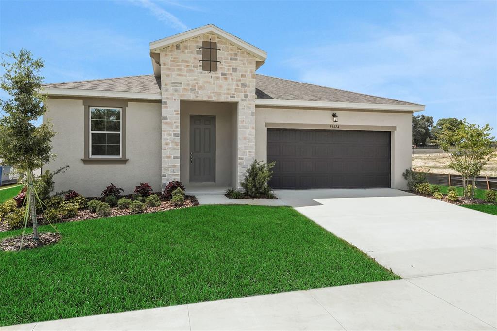 35424 Tuscan Hill Road Dade City, FL 33525 - Photo 6 of 42 a front view of a house with a garden and yard