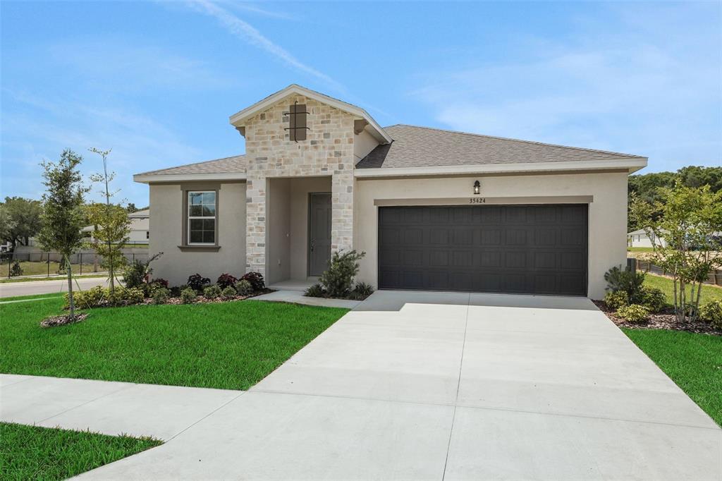 35424 Tuscan Hill Road Dade City, FL 33525 - Photo 7 of 42 a front view of a house with a yard and garage