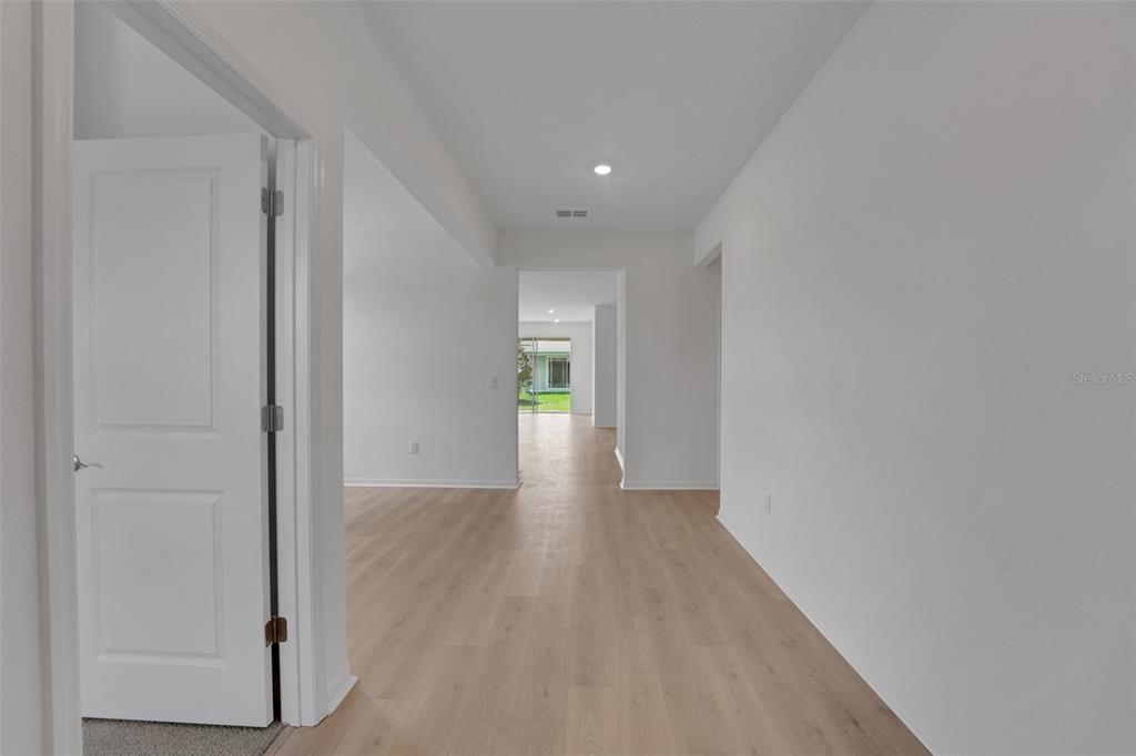 35424 Tuscan Hill Road Dade City, FL 33525 - Photo 9 of 42 a view of a hallway with wooden floor