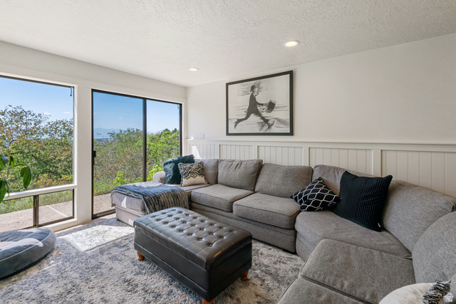 1900 North 100 East Provo, UT 84604 - Photo 27 of 49 Living area featuring extensive window-paned walls, sliding glass door access, white wainscoting, recessed ceiling lighting, and textured ceilings