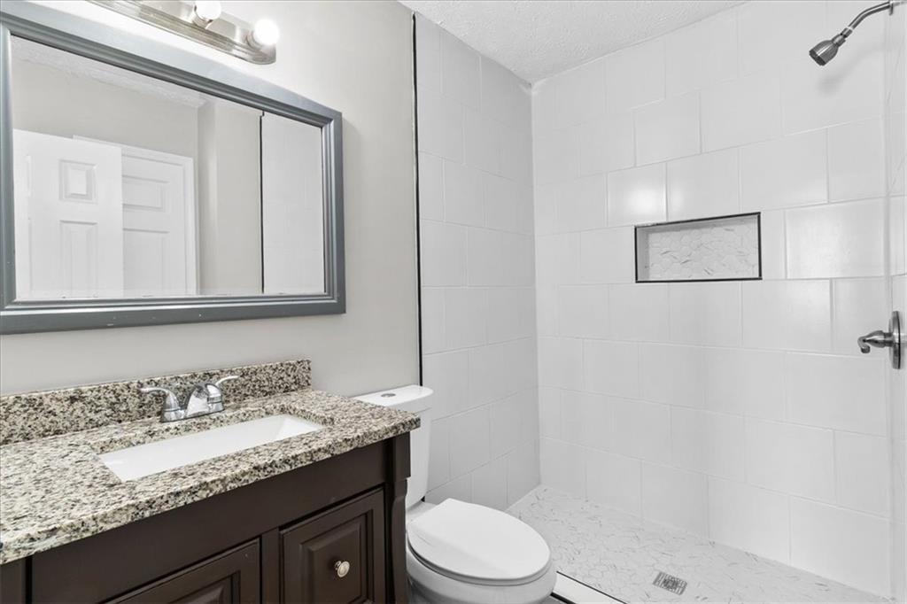 3483 Kingswood Run Decatur, GA 30034 - Photo 16 of 19 a bathroom with a granite countertop sink a toilet and a mirror