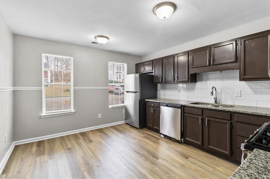 3483 Kingswood Run Decatur, GA 30034 - Photo 4 of 19 a kitchen with granite countertop wooden floors stainless steel appliances a sink and a window