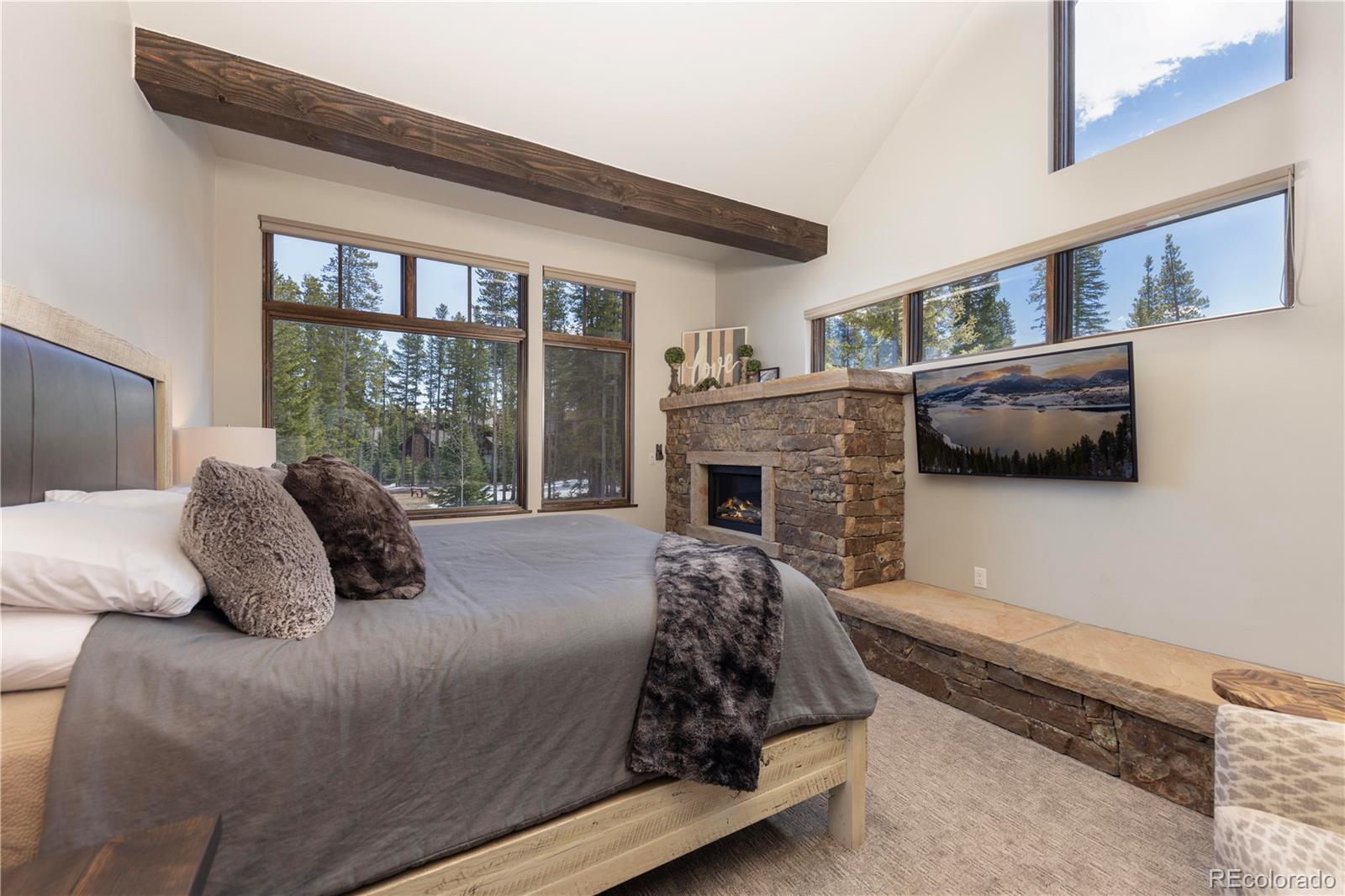 92 Cucumber Creek Road Breckenridge, CO 80424 - Photo 16 of 37 a bedroom with a bed a fireplace and a large window