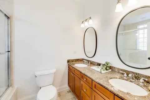 a bathroom with a granite countertop toilet a sink and a mirror