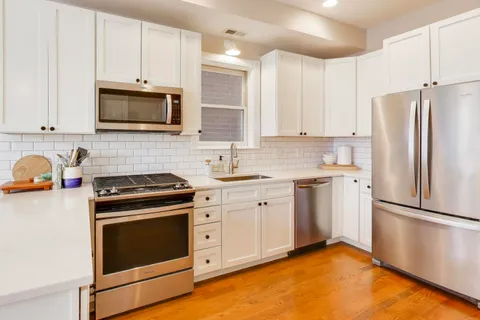 a kitchen with cabinets stainless steel appliances and a counter space