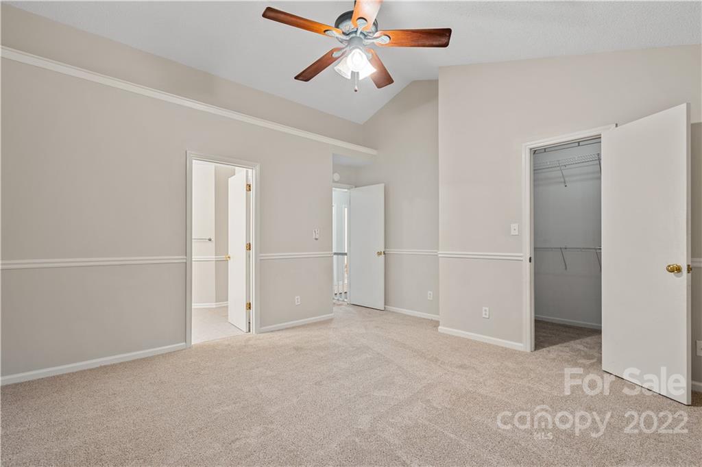 12021 Danby Road Pineville, NC 28134 - Photo 18 of 27 an empty room with closet and a chandelier fan