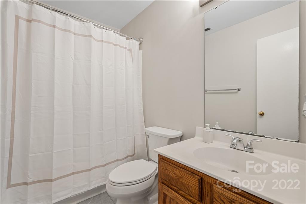 12021 Danby Road Pineville, NC 28134 - Photo 22 of 27 a bathroom with a granite countertop sink toilet and a mirror