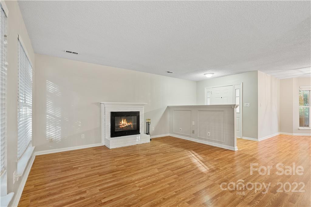 12021 Danby Road Pineville, NC 28134 - Photo 10 of 27 a view of empty room with wooden floor and fireplace