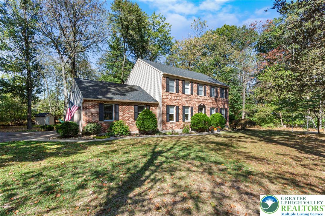 569 Pine Tree Drive Nazareth, PA 18064 - Photo 2 of 29 a view of a big yard in front of a brick house with large windows
