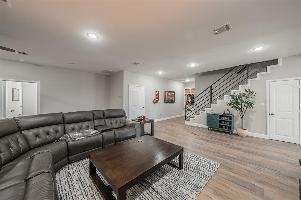 117 Rock Salt Drive Springtown, TX 76082 - Photo 14 of 38 Open concept living area featuring light wood-finish flooring, recessed ceiling lighting, and a modern staircase with black metal railings