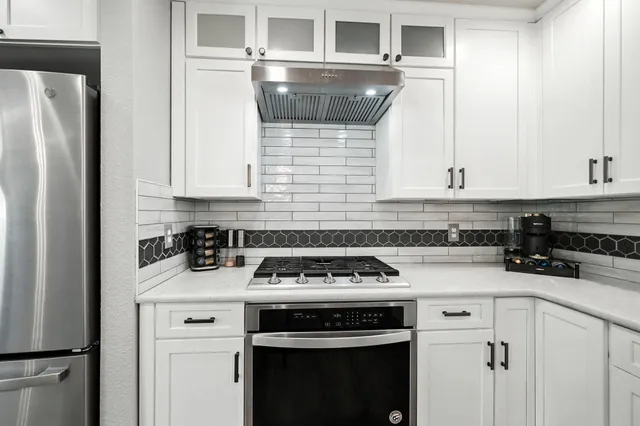 a kitchen with a stove and white cabinets