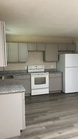 a white kitchen with a sink a stove a microwave and cabinets
