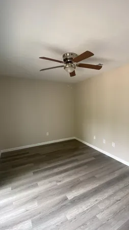 a view of a room with an empty space and wooden floor