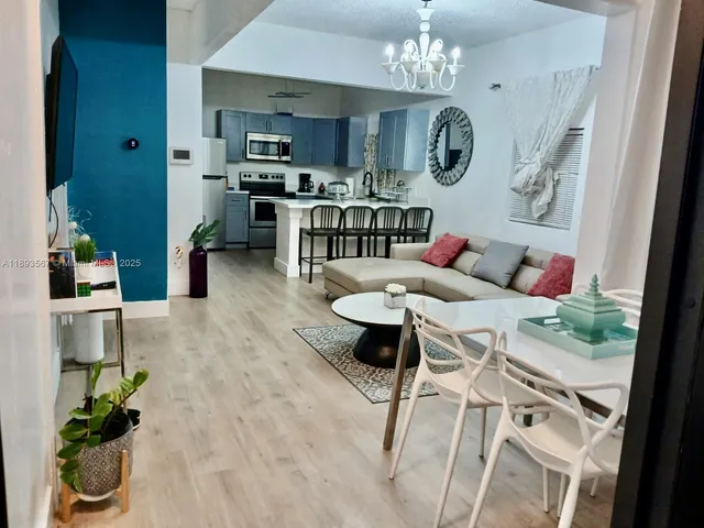 a living room with furniture dining table and a chandelier