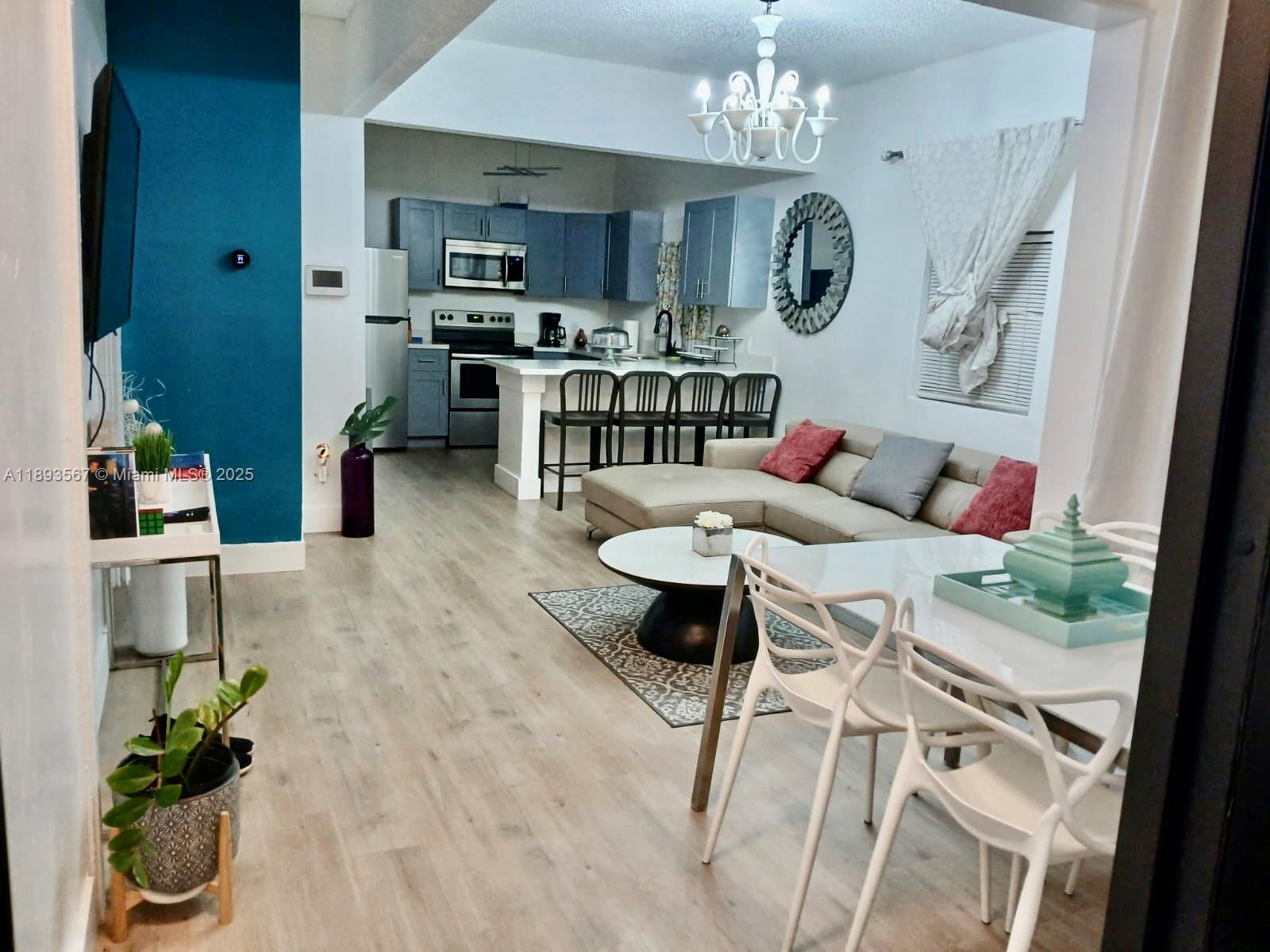 a living room with furniture dining table and a chandelier