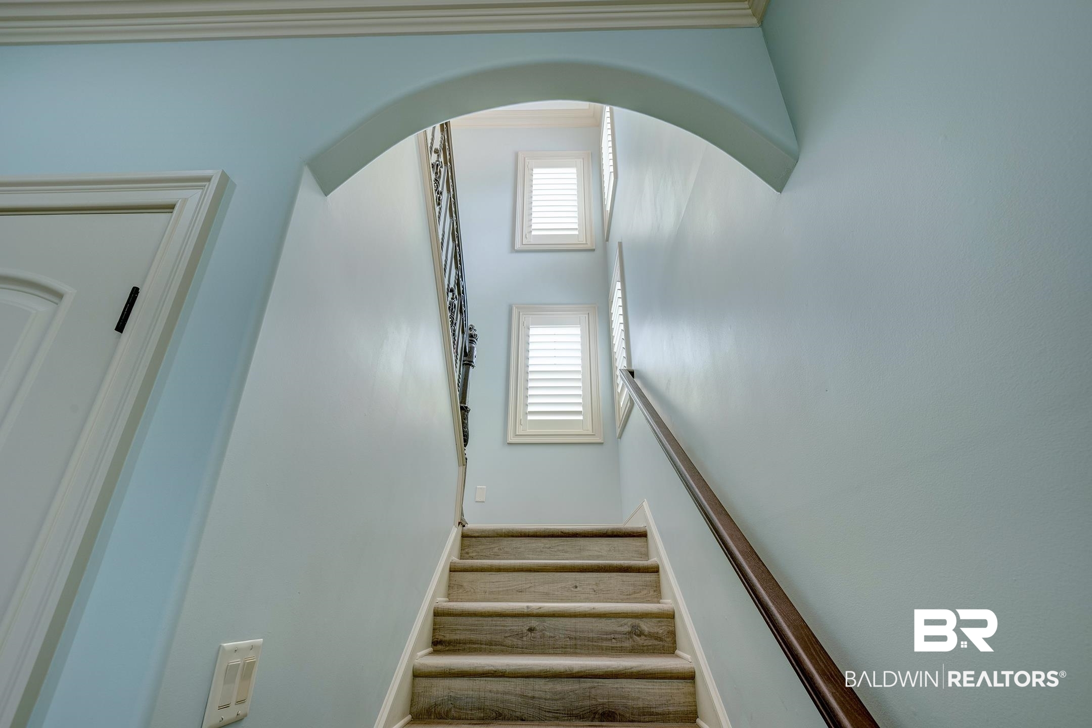 9357 Lakeview Drive Foley, AL 36535 - Photo 56 of 68 Staircase with wood-finish treads and risers, featuring a dark wood handrail and wrought iron balusters