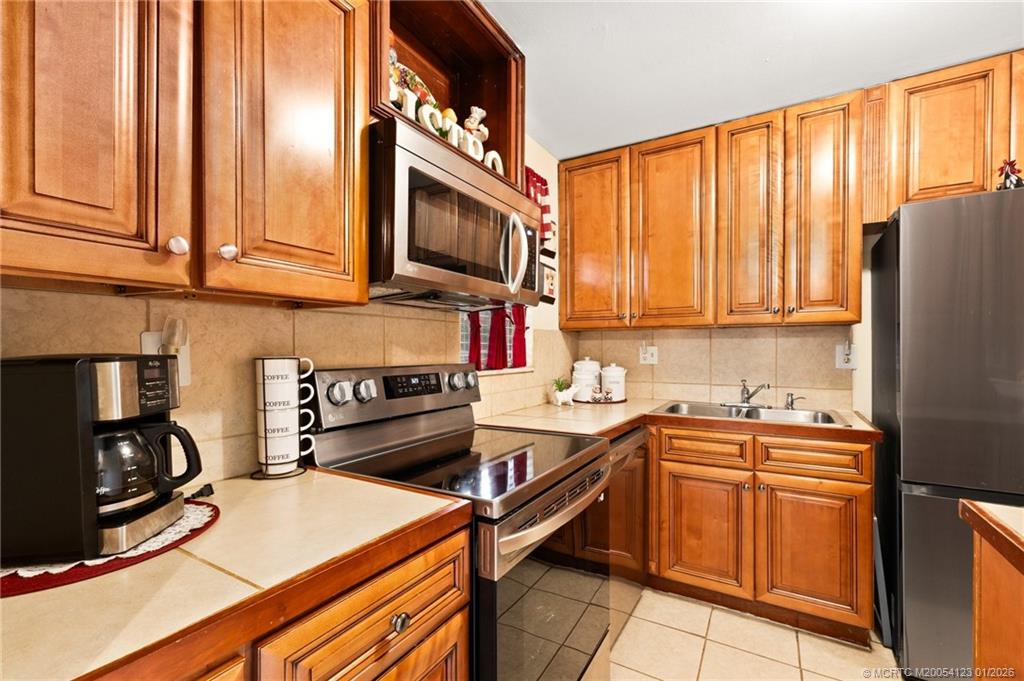 1980 Southwest Palm City Road, Unit 50J Stuart, FL 34994 - Photo 5 of 37 a kitchen with stainless steel appliances a stove sink and cabinets
