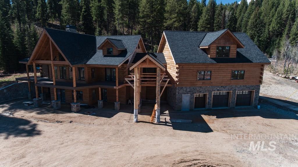 31-33 Bacon Creek Road Cascade, ID 83611 - Photo 2 of 23 Cabin featuring stone siding, driveway, an attached garage, and log siding
