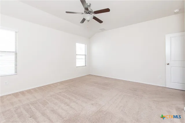 an empty room with windows and fan