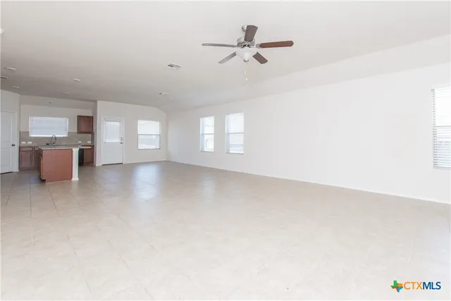 a view of a livingroom with a ceiling fan and window