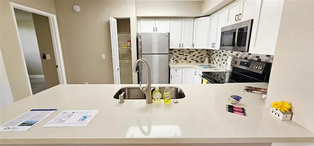 a kitchen with a refrigerator and a stove top oven