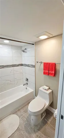 a white toilet sitting next to a bath tub and shower