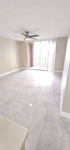 an empty room with windows and refrigerator