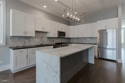 a kitchen with a refrigerator a microwave a sink and cabinets