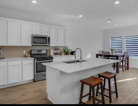 a kitchen with appliances a sink and cabinets