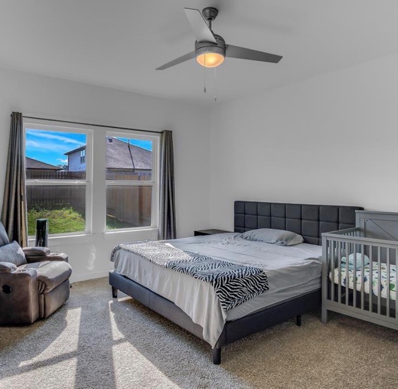 14258 Wonder Lake Lane Conroe, TX 77384 - Photo 11 of 12 a bedroom with a bed couch and a large window