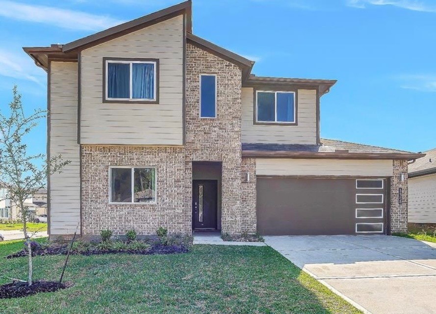 14258 Wonder Lake Lane Conroe, TX 77384 - Photo 2 of 12 a front view of a house with a yard and garage