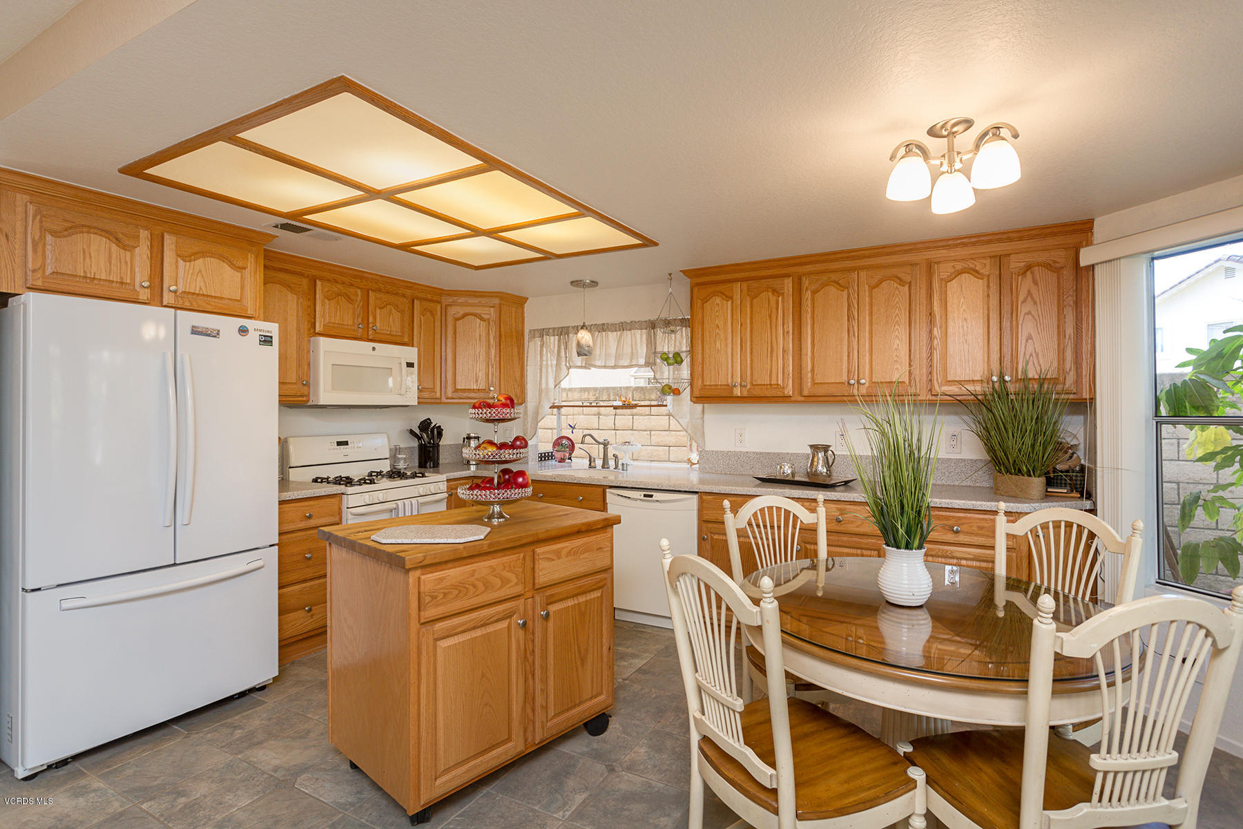 75 Valley Crest Road Simi Valley, CA 93065 - Photo 14 of 33 a kitchen with stainless steel appliances granite countertop a stove a sink dishwasher a refrigerator with a dining table and chairs