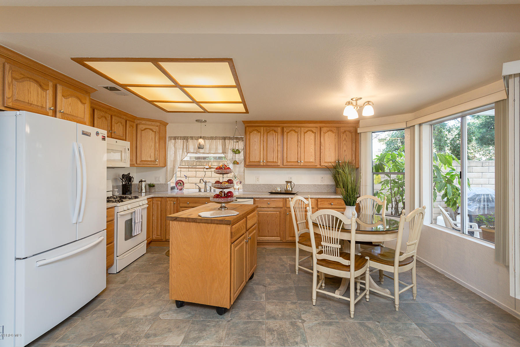 75 Valley Crest Road Simi Valley, CA 93065 - Photo 10 of 33 a kitchen with a refrigerator a stove a sink and a dining table with garden view