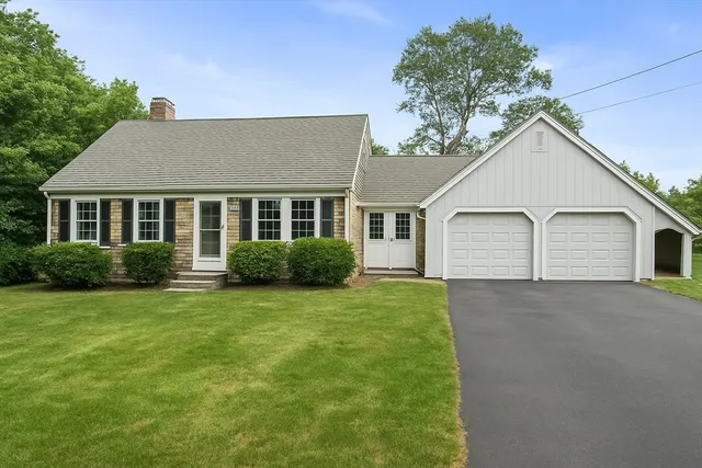 a view of a house with a yard and potted plants