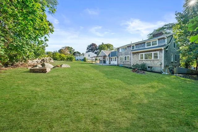 a view of a house with a big yard plants and large trees