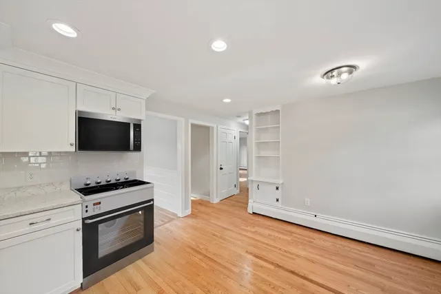 a kitchen with granite countertop a stove and a microwave