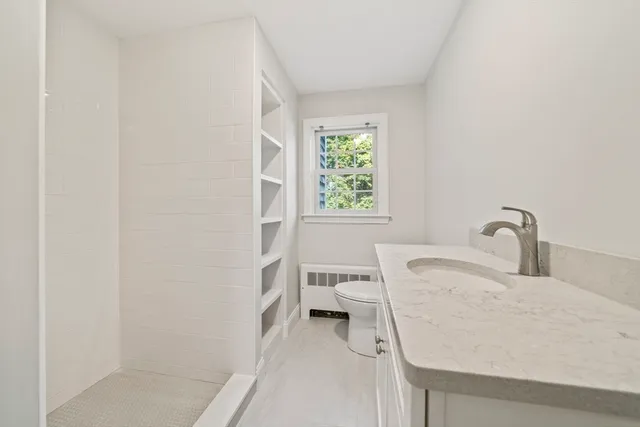 a bathroom with a sink a toilet and a window