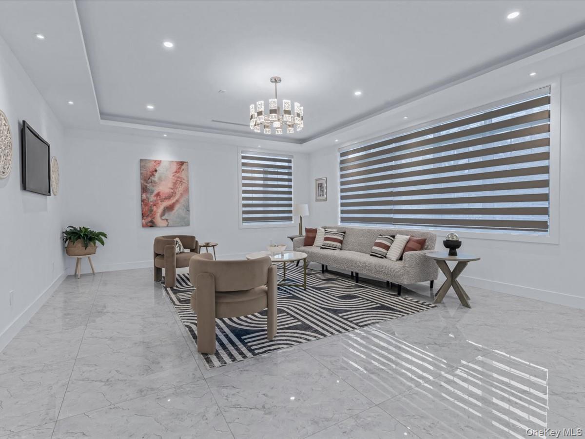 233-12 Bay Street Queens, NY 11363 - Photo 13 of 46 Living room with a raised ceiling, recessed lighting, light marble finish flooring, and a chandelier