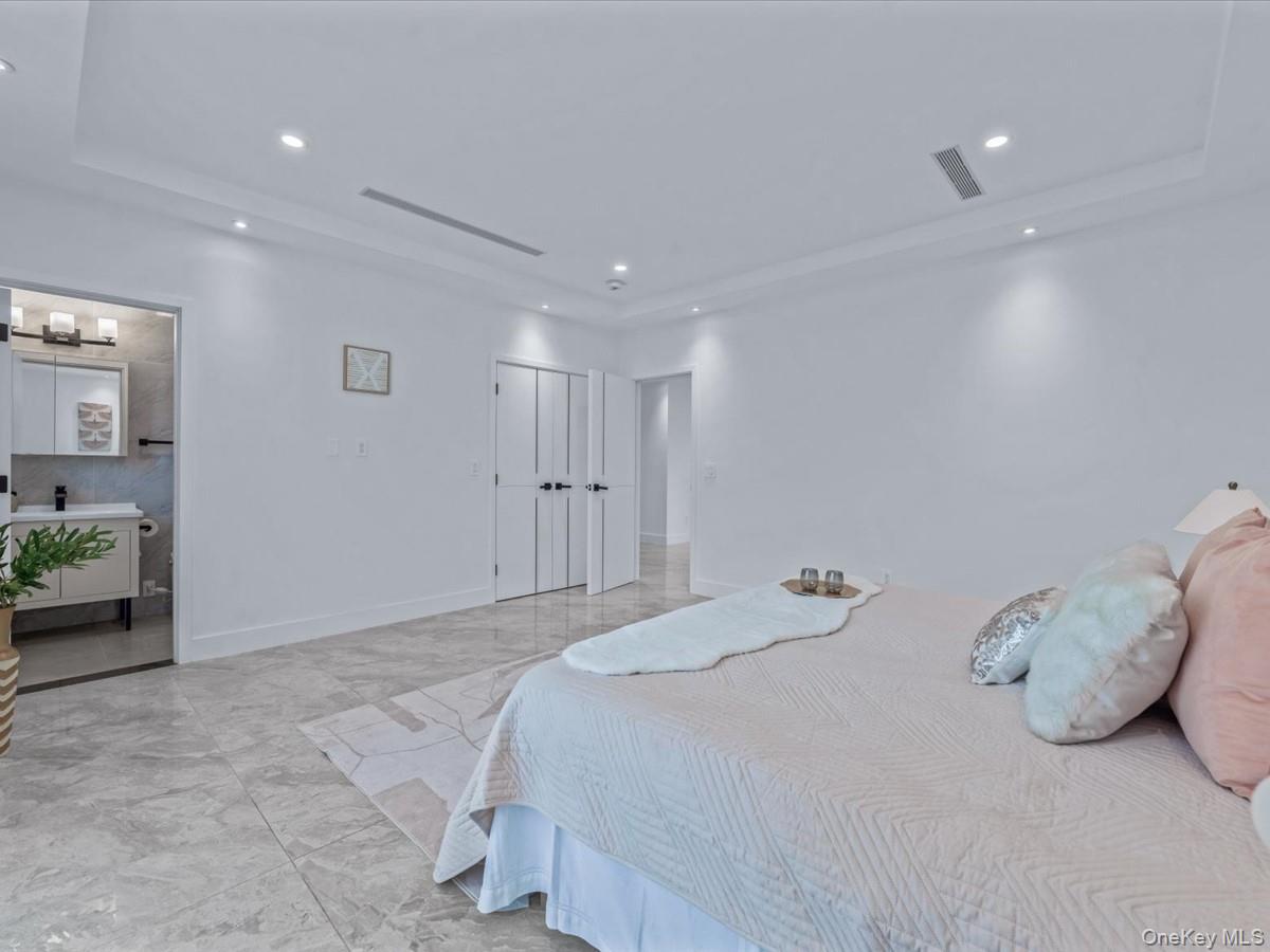 233-12 Bay Street Queens, NY 11363 - Photo 21 of 46 Bedroom featuring a raised ceiling, recessed lighting, and a closet