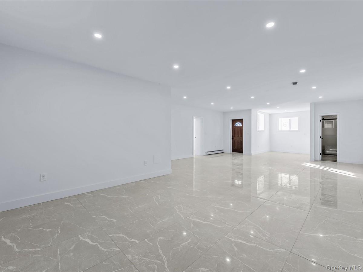 233-12 Bay Street Queens, NY 11363 - Photo 30 of 46 Unfurnished living room with recessed lighting, light marble finish flooring, and a baseboard radiator