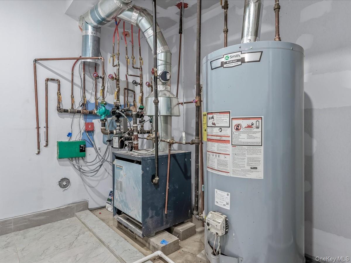 233-12 Bay Street Queens, NY 11363 - Photo 34 of 46 Utility room featuring water heater and a heating unit