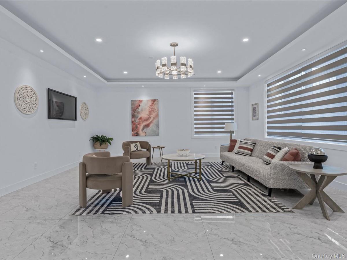 233-12 Bay Street Queens, NY 11363 - Photo 6 of 46 Living room with a tray ceiling, a chandelier, recessed lighting, and marble finish flooring
