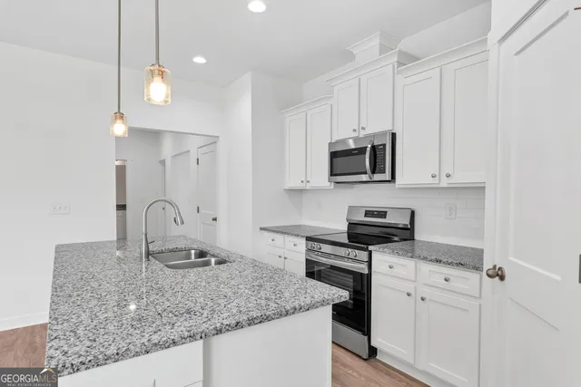 a kitchen with stainless steel appliances granite countertop a sink a stove and a microwave