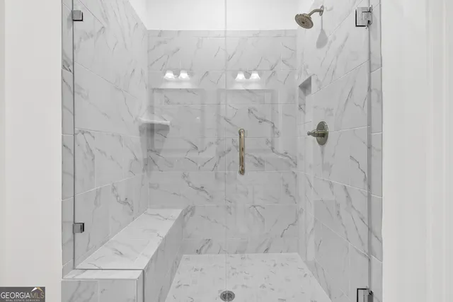 a bathroom with a granite countertop sink mirror and shower