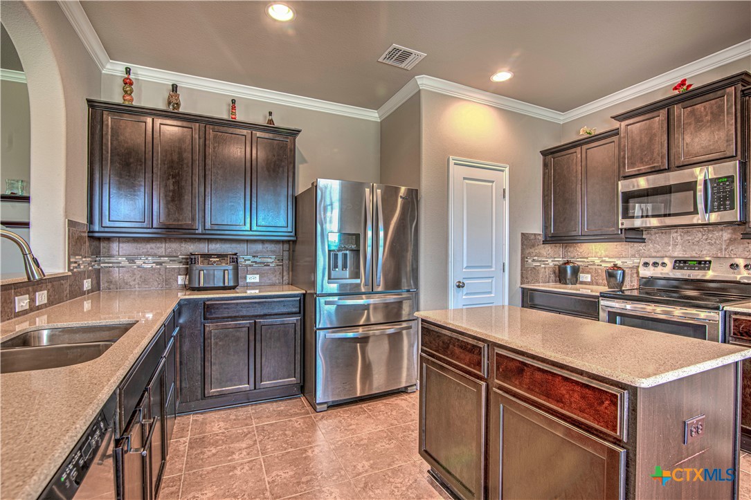 623 Coventry Drive Temple, TX 76502 - Photo 14 of 38 a kitchen with a sink stove and refrigerator