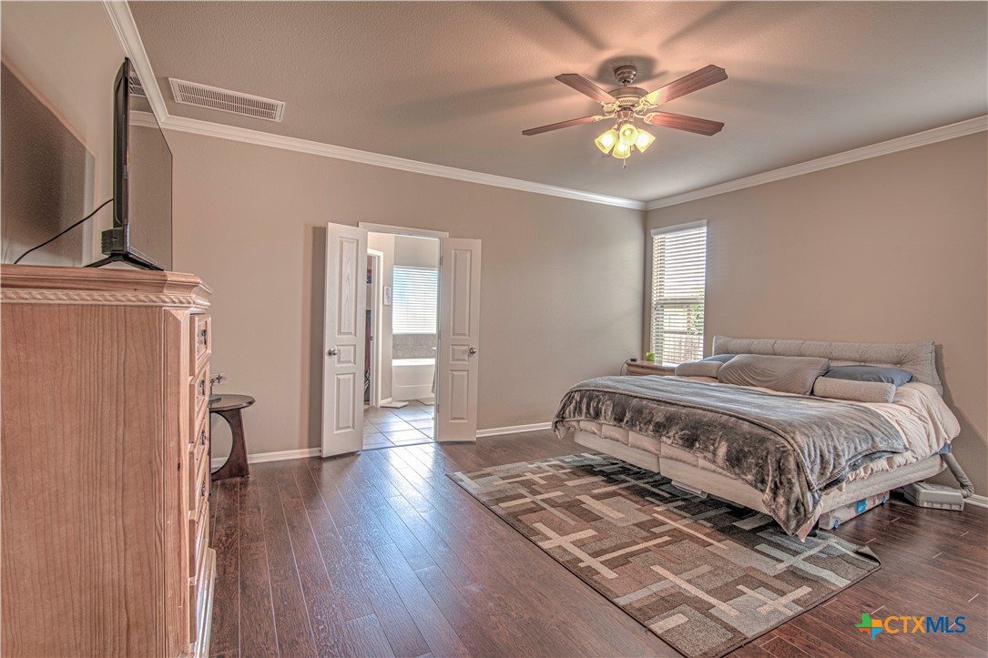623 Coventry Drive Temple, TX 76502 - Photo 17 of 38 a bedroom with a bed and a chandelier