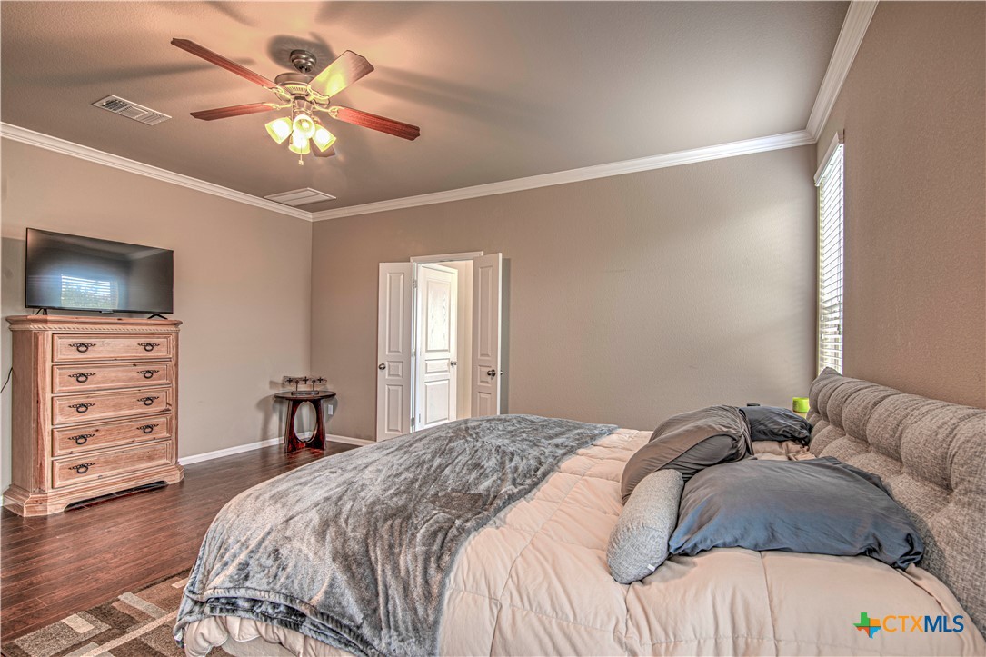 623 Coventry Drive Temple, TX 76502 - Photo 18 of 38 a bedroom with a bed and a chandelier