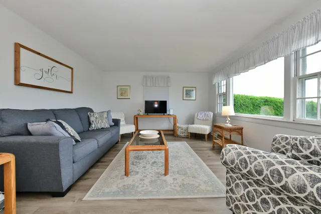 a living room with furniture large window and a table